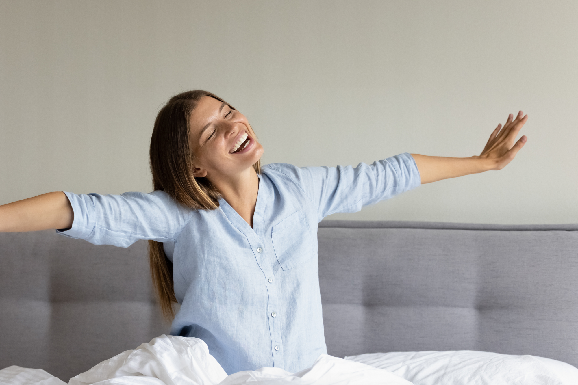 a person standing in their bed with their arms outstretched